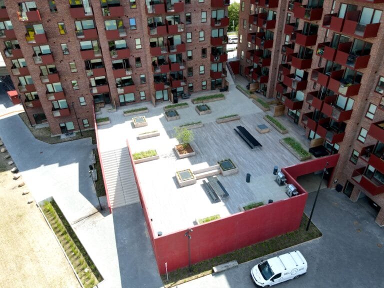 Moderne gårdhave mellem røde boligbygninger