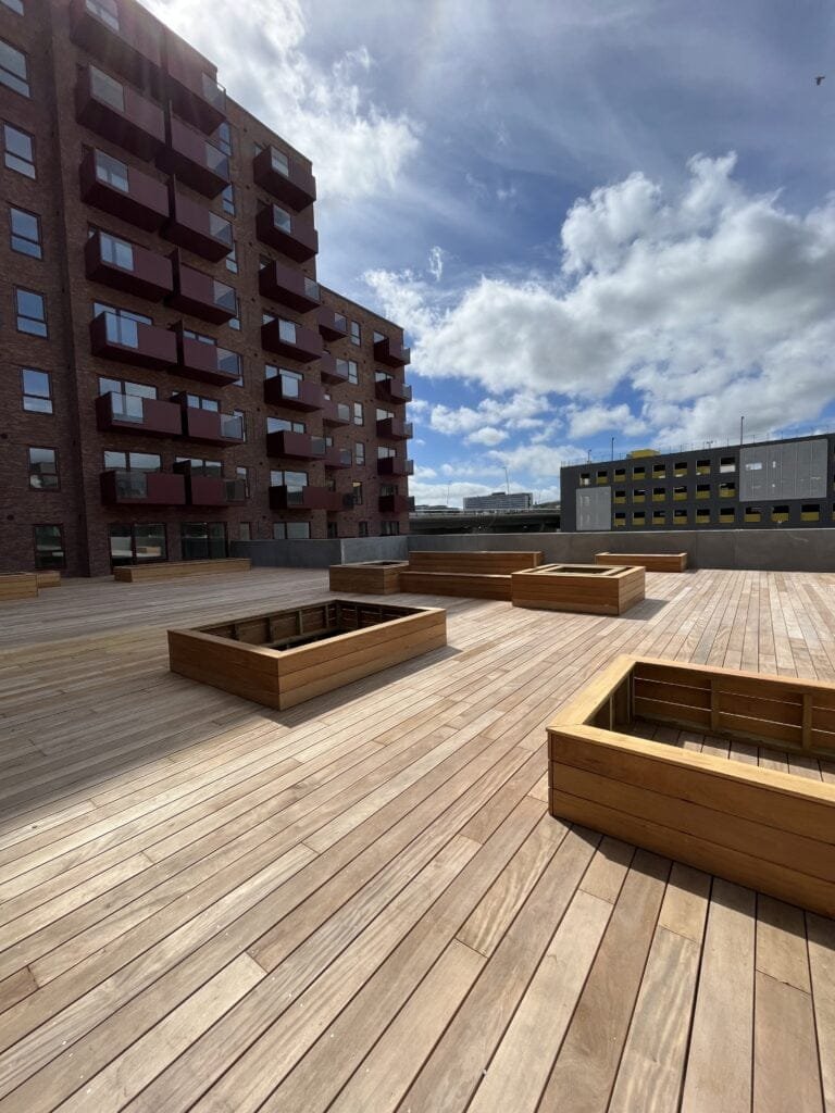 Træterrasse ved moderne lejlighedsbygning med altaner