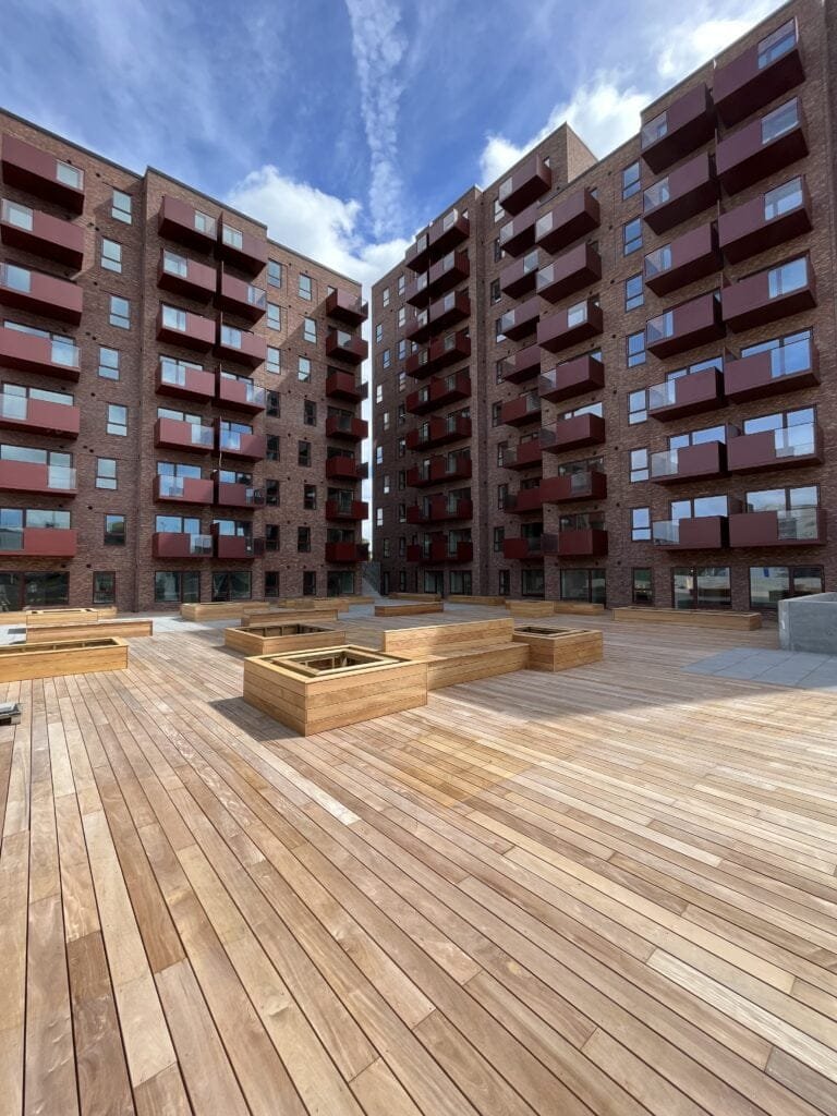 Moderne lejlighedsbygning med træterrasse og altaner