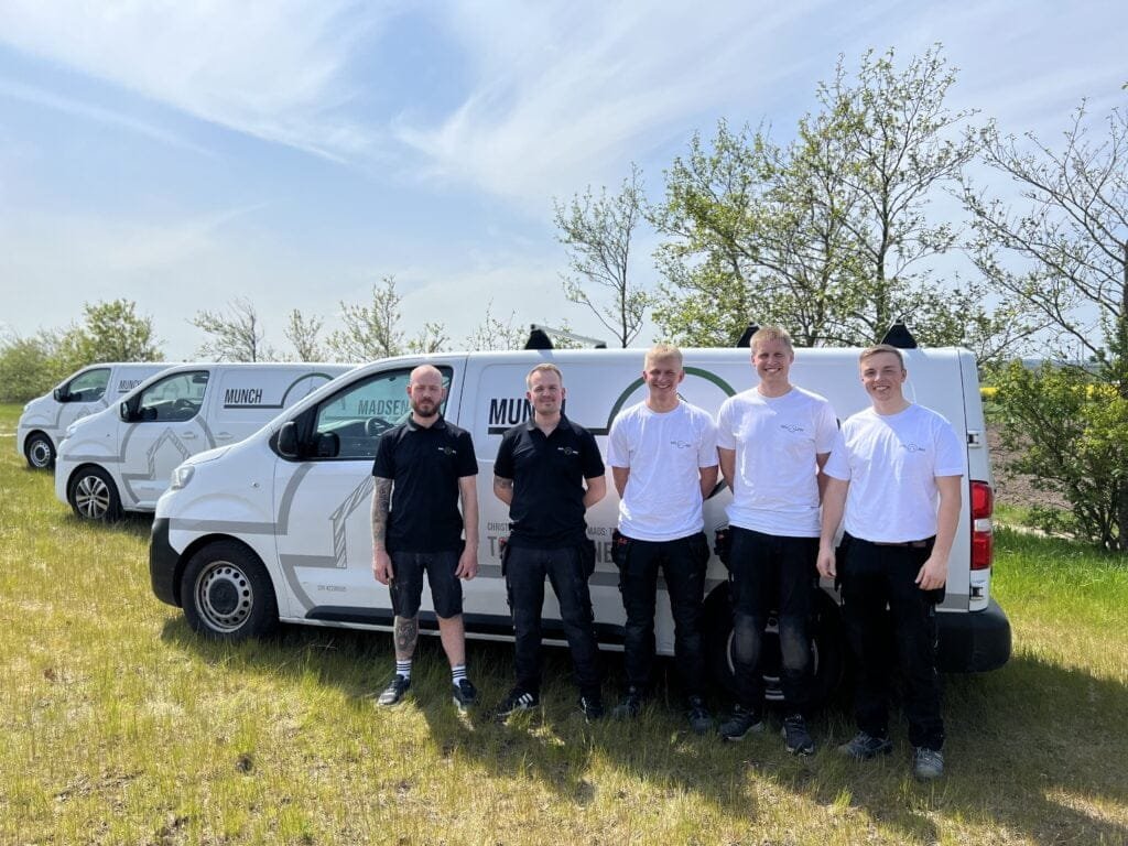 Team foran firmabiler udendørs på solrig dag