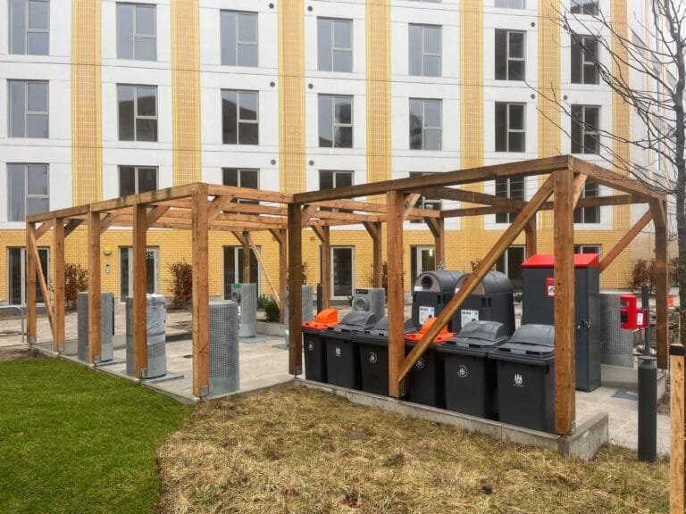 Affaldssorteringsstation foran moderne lejlighedsbygning